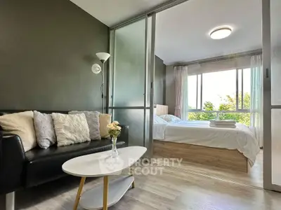 Modern studio apartment with cozy living area and bright bedroom view.