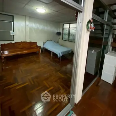 Spacious room with wooden flooring and minimalist furniture in a cozy home setting.