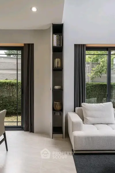 Modern living room with sleek design and garden view through large windows.