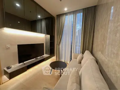 Modern living room with sleek design, large TV, and floor-to-ceiling windows offering natural light.