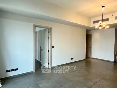 Spacious modern living room with elegant lighting and tiled flooring in a contemporary apartment.