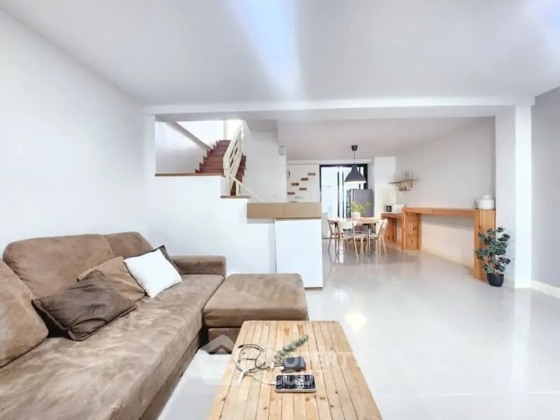 Spacious open-plan living room with modern decor and natural light.