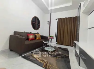 Modern living room with stylish sofa, elegant rug, and chic decor in a cozy apartment.