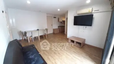Spacious living room with modern furnishings and wooden flooring in a cozy apartment.