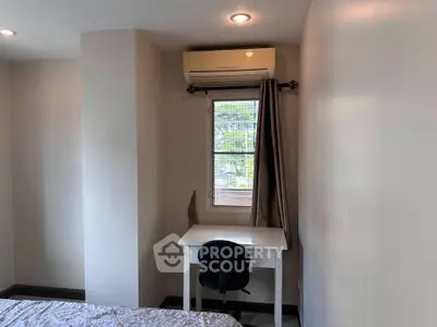 Cozy bedroom corner with desk and air conditioning, perfect for a compact study space.