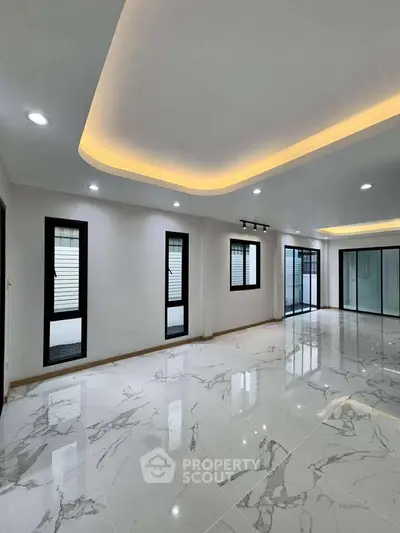 Spacious modern living room with elegant marble flooring and ambient lighting.