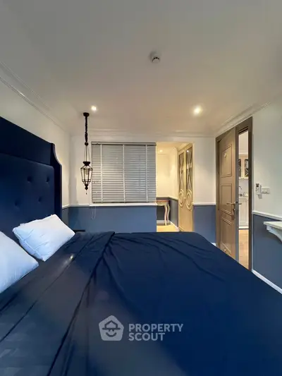 Elegant bedroom with navy blue bedding and stylish lighting