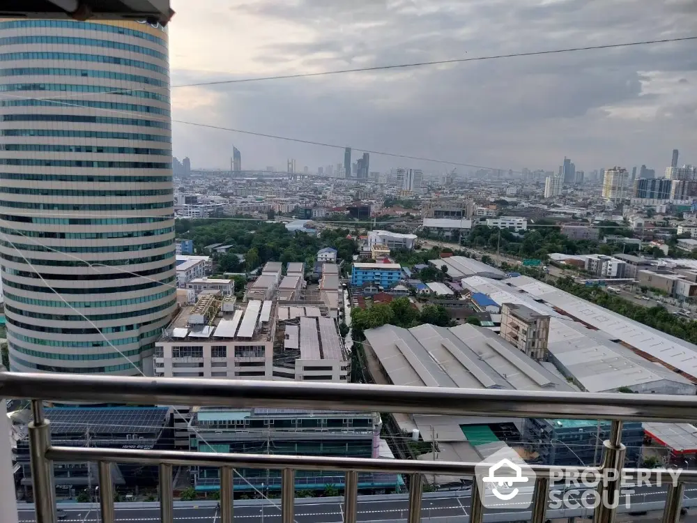 Stunning cityscape view from high-rise balcony overlooking urban skyline and modern architecture.