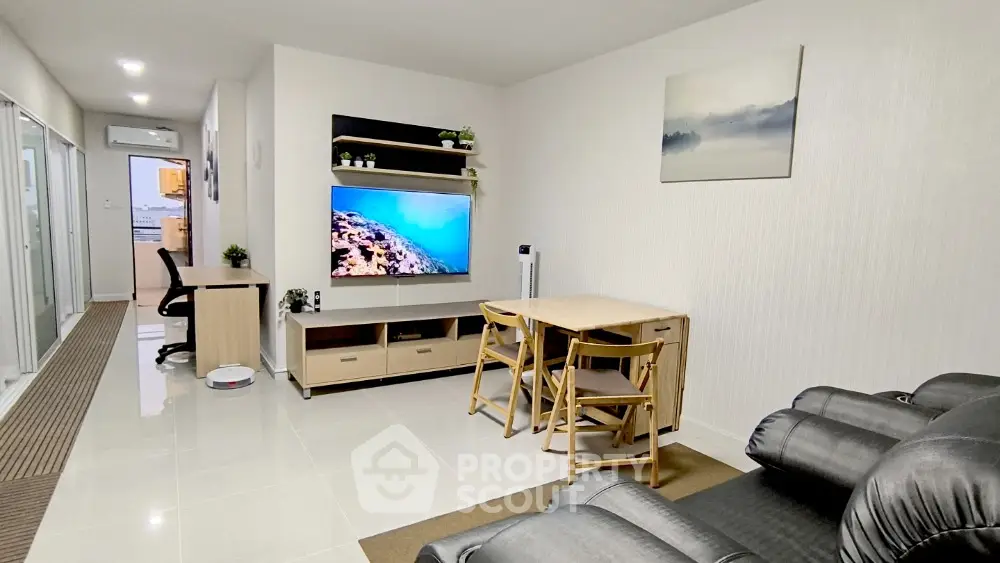 Modern living room with sleek furniture and wall-mounted TV in a stylish apartment