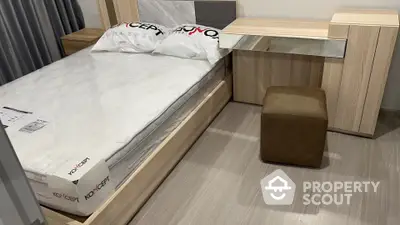 Modern minimalist bedroom with a sleek wooden bed frame, matching side table, and a cozy stool, all set on elegant laminate flooring.