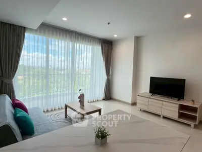 Modern living room with large window and stylish furniture, offering a bright and airy atmosphere.