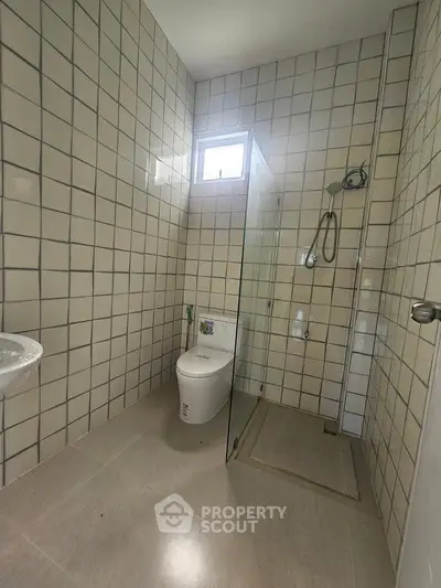 Modern bathroom with tiled walls and glass shower enclosure