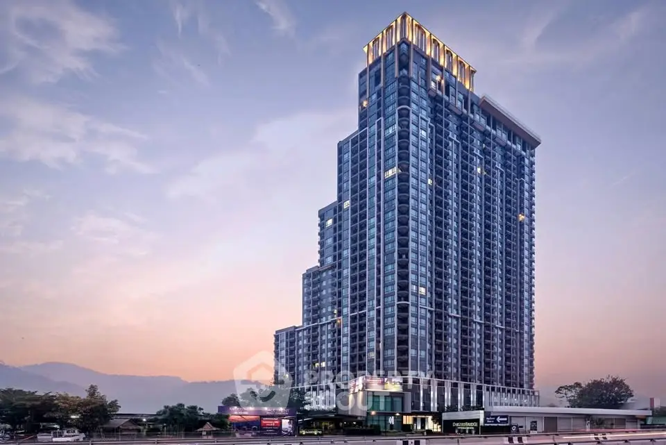 Stunning high-rise building with modern architecture and scenic mountain backdrop at sunset.