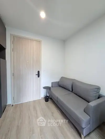 Modern living room with sleek gray sofa and wooden flooring, perfect for cozy relaxation.