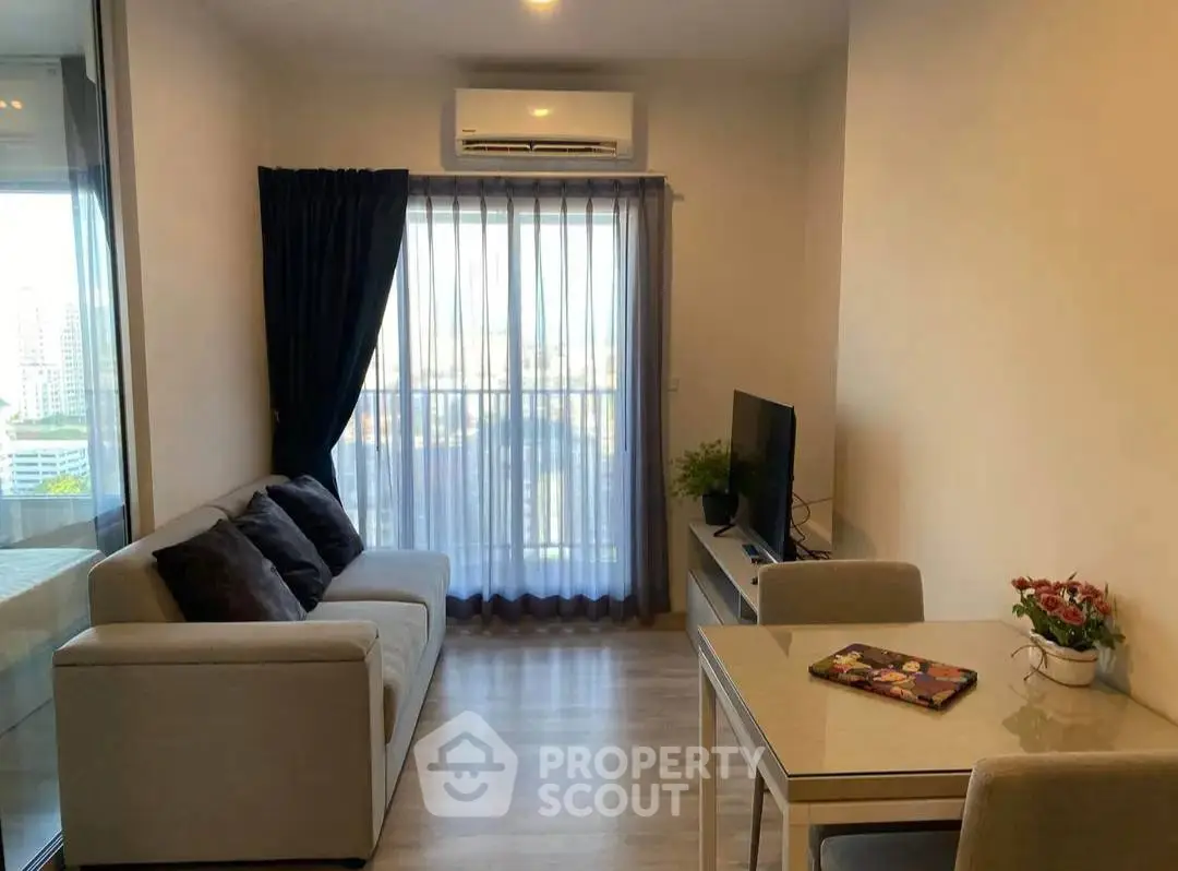 Cozy living room with modern decor and city view, featuring a comfortable sofa and sleek TV setup.