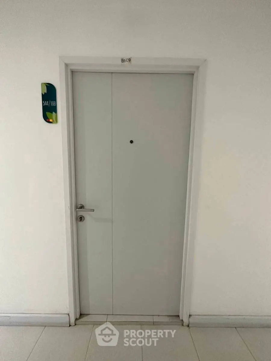 Modern apartment entrance with sleek door design and room number signage.