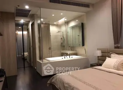 Luxurious bedroom with ensuite glass-walled bathroom and elegant decor
