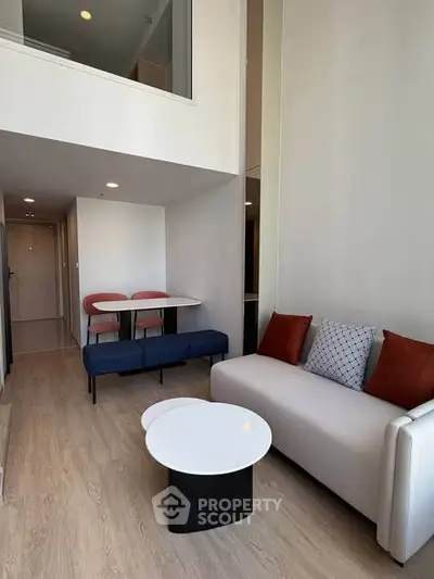 Modern living room with high ceiling and stylish furniture in a contemporary apartment.