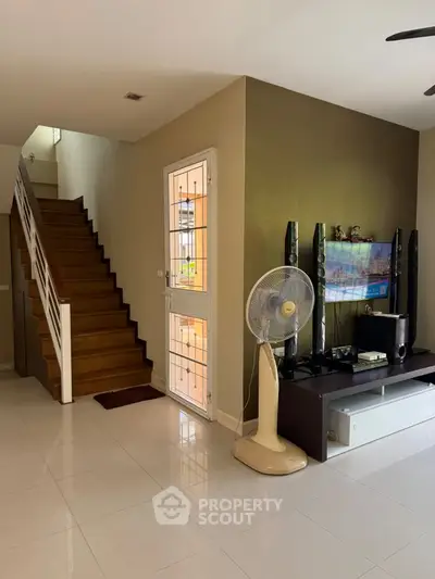 Spacious living area with modern staircase and entertainment center