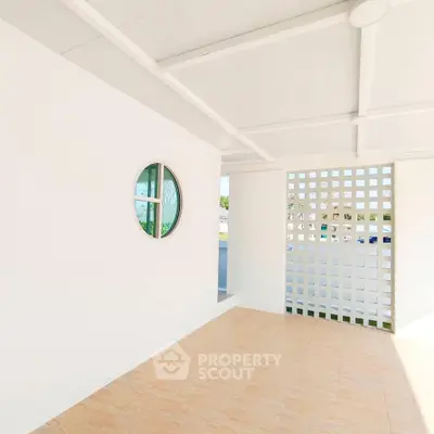 Bright minimalist balcony with circular window and lattice wall