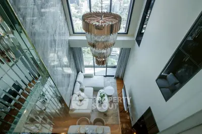 Luxurious high-ceiling living room with stunning chandelier and city view