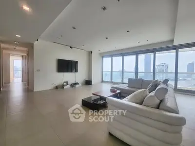 Spacious modern living room with panoramic city views and elegant furnishings.