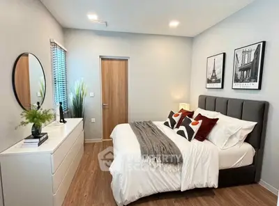 Modern bedroom with stylish decor and cozy ambiance, featuring elegant artwork and sleek furniture.