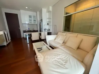 Modern living room with sleek white furniture and open kitchen layout