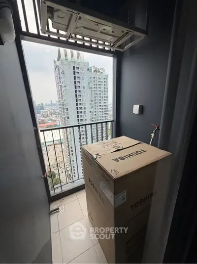 Compact balcony with city view and boxed appliance, ideal for urban living.