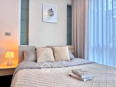 Cozy bedroom with modern decor and large window for natural light.