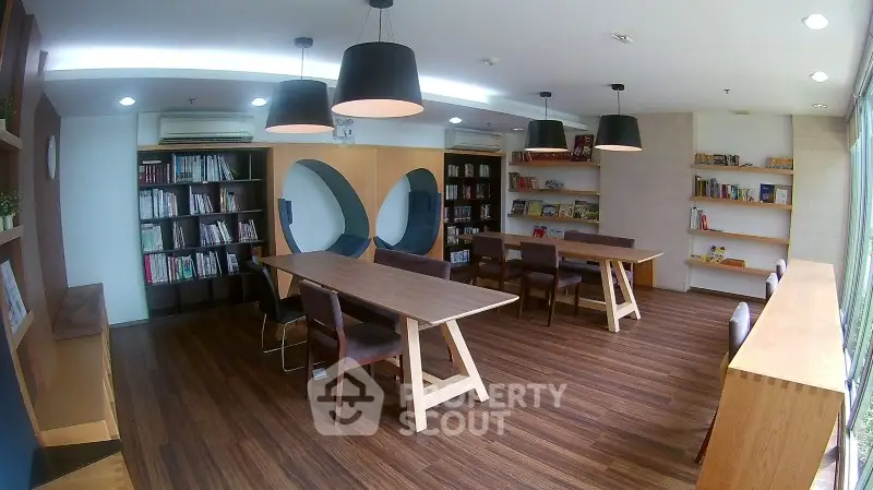 Modern library with stylish wooden flooring and contemporary furniture in a bright, airy space.