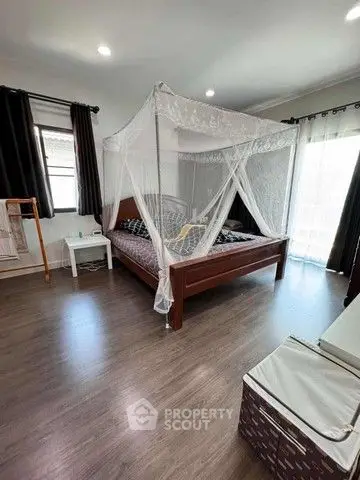 Spacious bedroom with elegant canopy bed and natural light