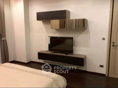 Modern bedroom with sleek TV setup and stylish wall-mounted cabinets.