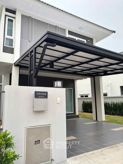 Modern two-story home with sleek design and covered carport in a serene neighborhood.