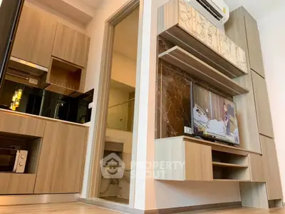 Modern living room with stylish wooden cabinetry and mounted TV, showcasing sleek interior design.