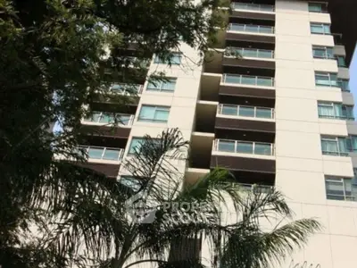 Modern high-rise building with lush greenery and spacious balconies.
