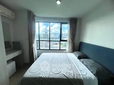 Modern bedroom with large window offering city view and natural light