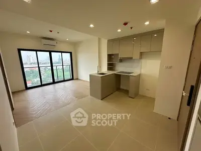 Modern open-plan kitchen and living room with city view in high-rise apartment.
