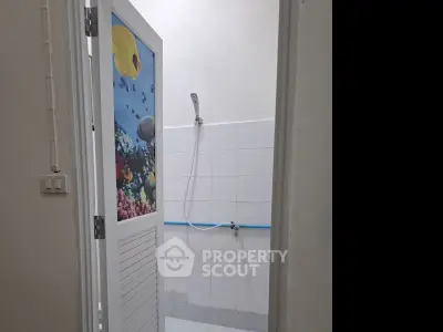Minimalist bathroom with shower and ocean-themed door design