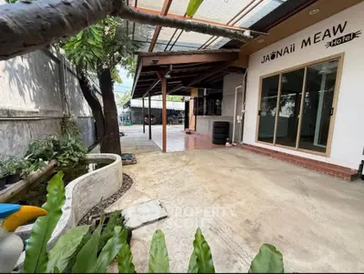 Charming hotel entrance with spacious outdoor area and lush greenery, perfect for relaxation and leisure.