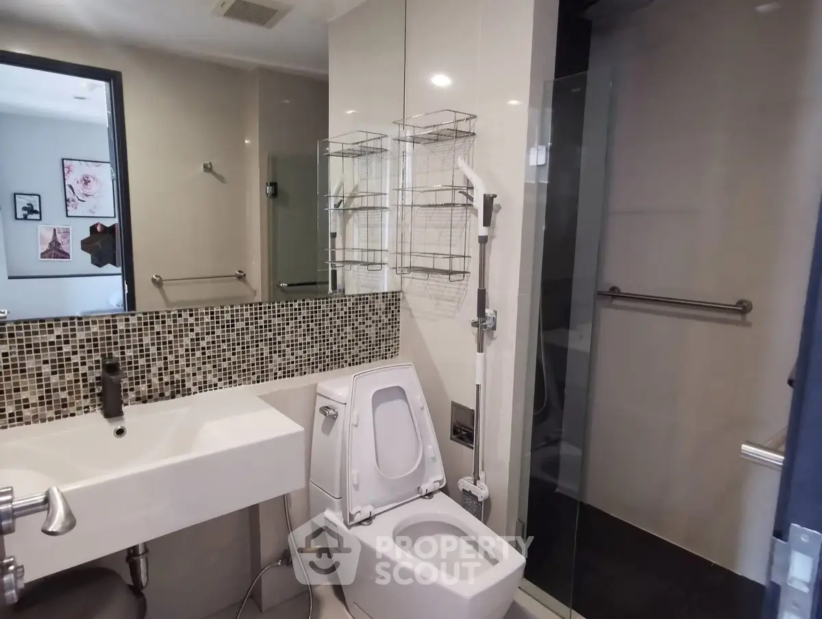 Modern bathroom with sleek fixtures and mosaic tile backsplash