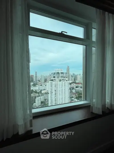 Stunning cityscape view from a high-rise window, showcasing urban skyline and modern architecture.