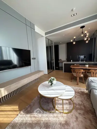 Modern living room with open kitchen, stylish furniture, and elegant lighting in a contemporary apartment.