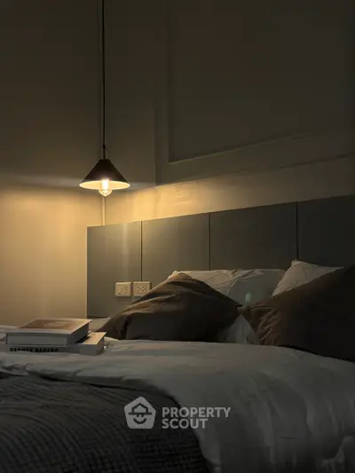 Cozy bedroom with modern lighting and plush bedding for ultimate relaxation.