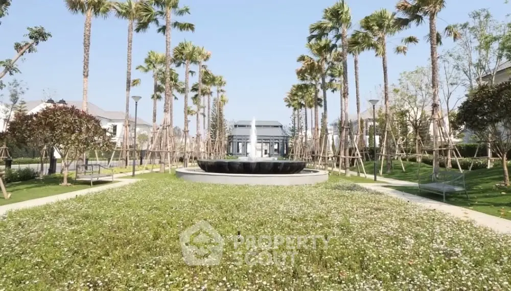 Luxurious garden view with palm trees and fountain in upscale residential area.