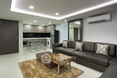 Modern living room with sleek kitchen, stylish furniture, and ambient lighting in a contemporary apartment.