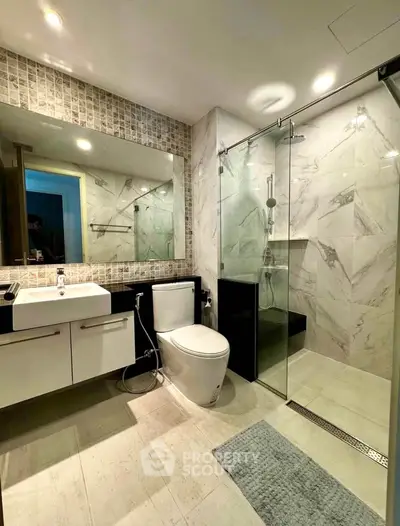 Modern bathroom with glass shower and sleek fixtures in luxury apartment