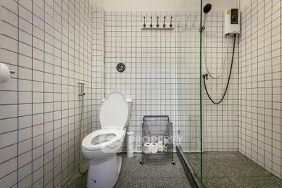 Modern bathroom with white tiled walls and glass shower enclosure