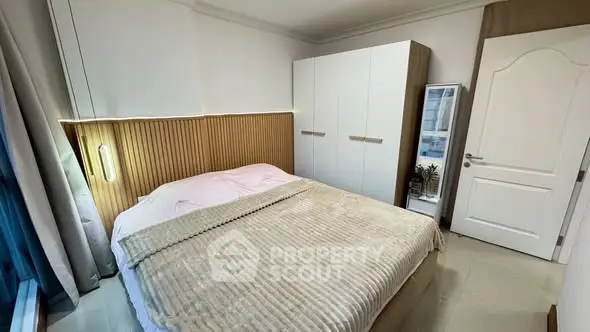 Cozy modern bedroom with stylish decor and ample storage space.