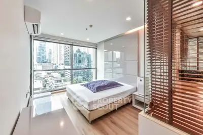 Modern bedroom with city view and large windows in high-rise apartment
